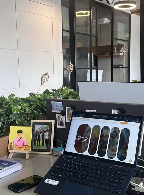 Desk with a laptop, framed photos and plants in the Mindphin office
