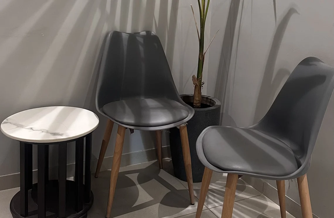 Waiting area with two grey chairs and a small marble-top table